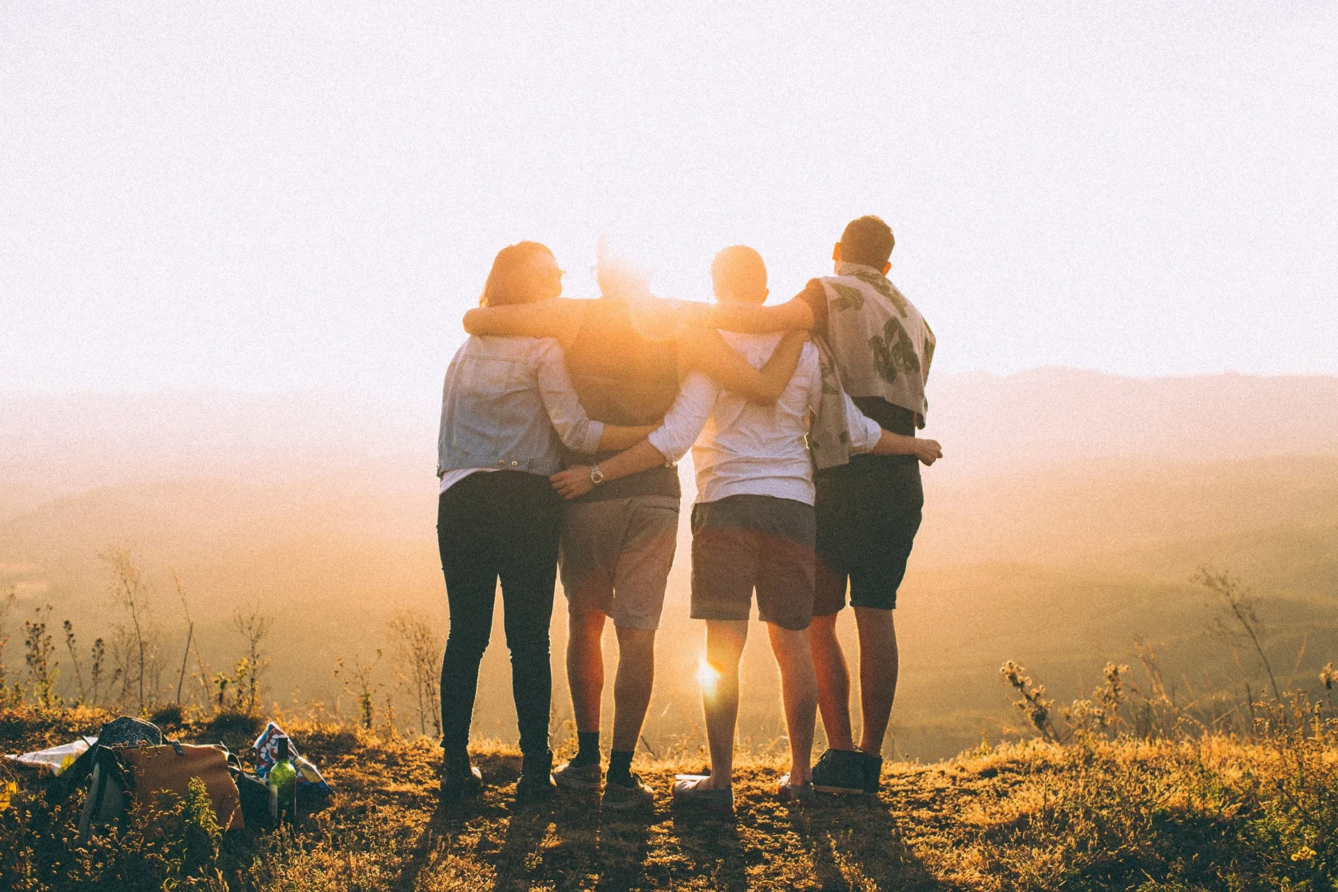Four friends from New Life Community Church standing arm in arm at sunset in Berkeley County, West Virginia